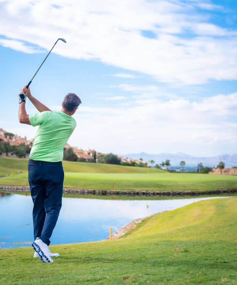 man-playing-golf-at-golf-club-by-a-lake