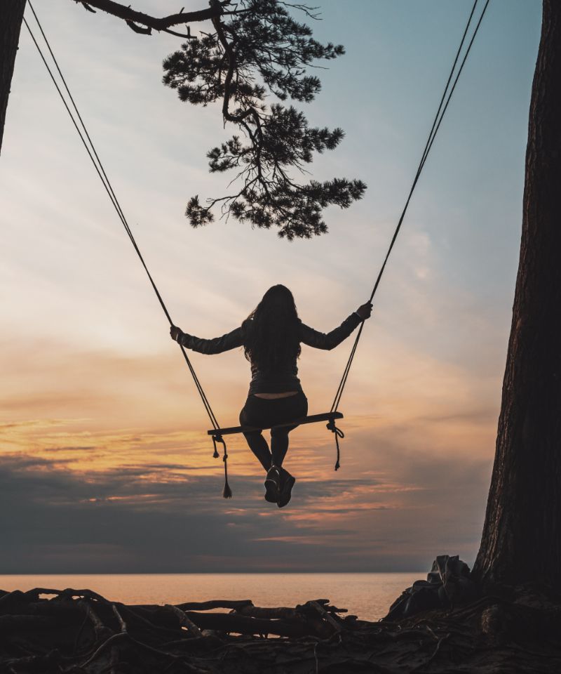 vertical-shot-of-a-female-on-a-handmade-swing-hang