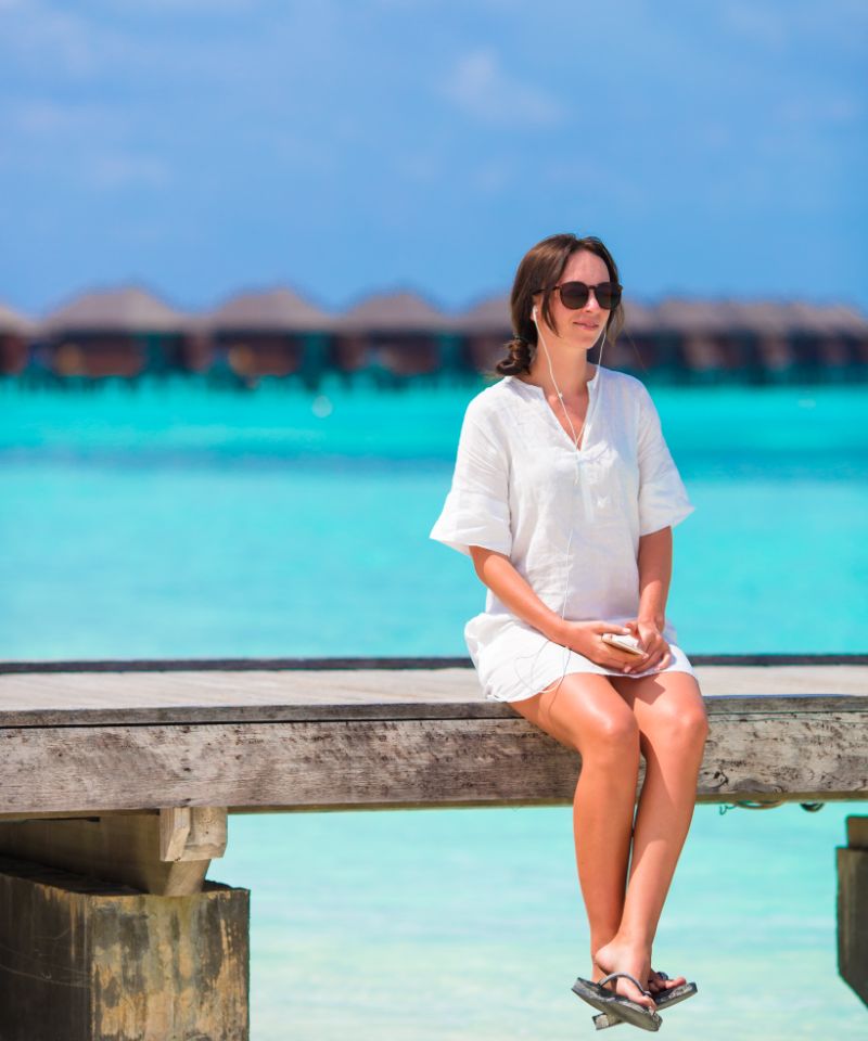 maldives-girl-listening-music-on-wooden-pier