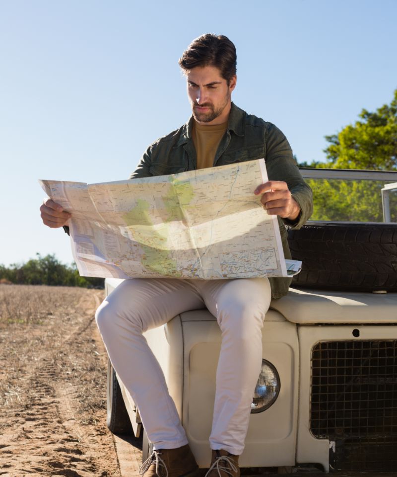 man-reading-map-while-sitting
